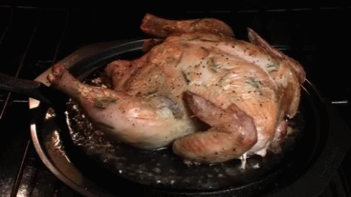 A Roasted Chicken Is Being Cooked In A Pan On A Stove GIF