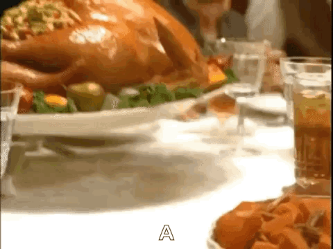 A Roasted Turkey Is Sitting On A White Plate On A Table Next To A Glass Of Wine . GIF