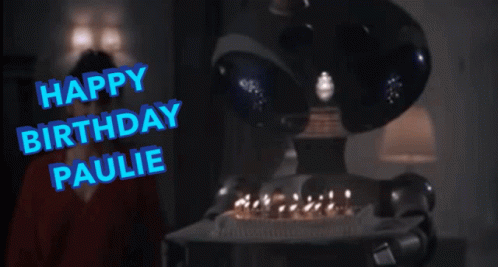 A Robot Holding A Birthday Cake With The Words Happy Birthday Paulie Written In Blue GIF