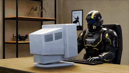 A Robot Is Sitting At A Desk Using A Computer With A Poster On The Wall That Says Spill On GIF