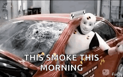 A Robot Is Sitting In A Car With A Broken Windshield And The Words `` This Smoke This Morning '' . GIF