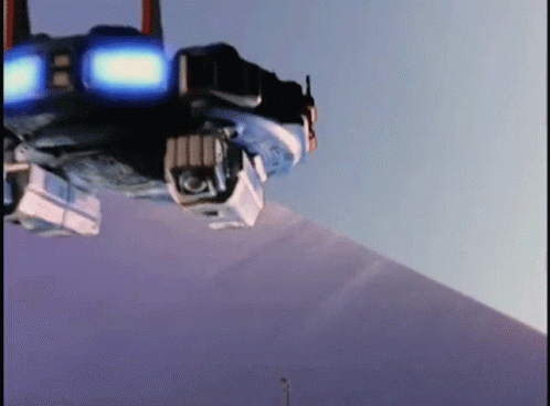 A Robot Is Sitting On Top Of A Snow Covered Mountain . GIF
