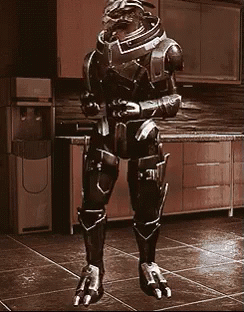 A Robot Is Standing In A Kitchen In Front Of A Water Cooler GIF
