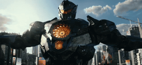 A Robot Stands In Front Of A City With A Blue Sky And Clouds GIF