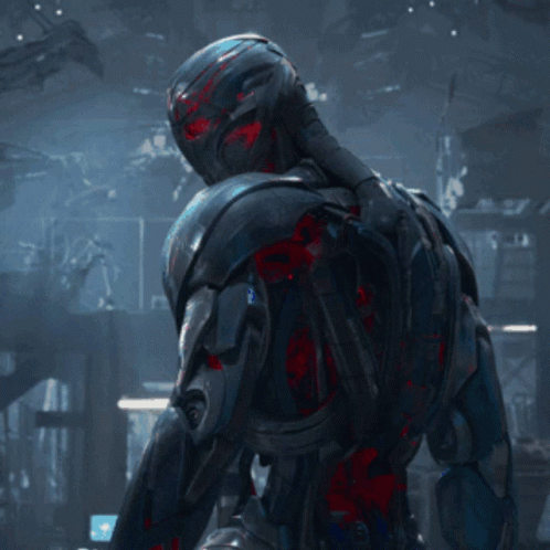 Robot With Red Eyes Standing In Darkness GIF