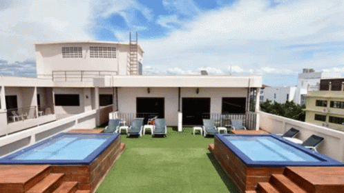 A Rooftop With A Swimming Pool And Chairs GIF