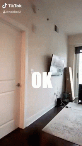 A Room With A Tv On The Wall And The Word Ok Written On It GIF