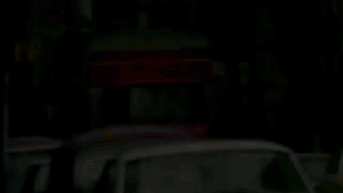 A Row Of Cars Are Parked On The Side Of The Road GIF