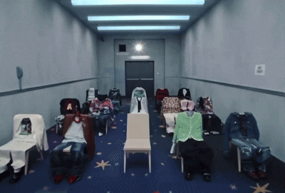 A Row Of Chairs Are Lined Up In A Hallway With A Sign On The Wall That Says E GIF