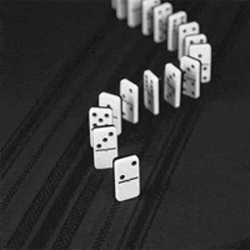 A Row Of Dominoes Are Lined Up On A Black Surface GIF