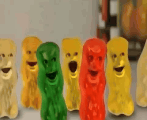 A Row Of Gummy Bears With Their Mouths Wide Open GIF