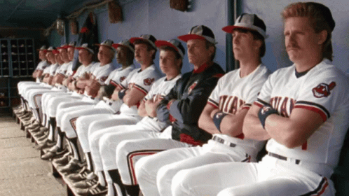 A Row Of Indians Baseball Players Sit In A Dugout GIF