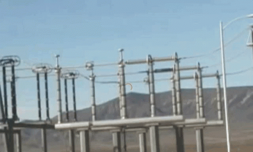 A Row Of Power Lines With Mountains In The Background GIF