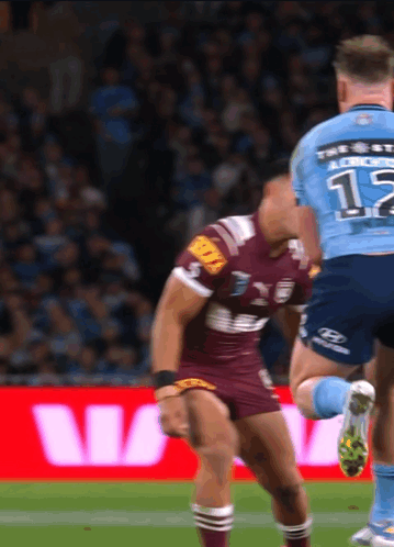 A Rugby Player Wearing A Number 12 Jersey Is Being Tackled By Another Player GIF