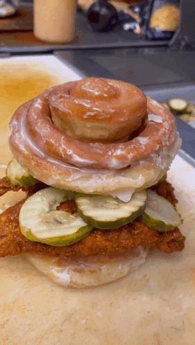A Sandwich With Pickles And A Cinnamon Roll On Top GIF