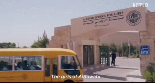 A School Bus Is Parked In Front Of A Sign That Says " The Girls Of Alrawabi " GIF