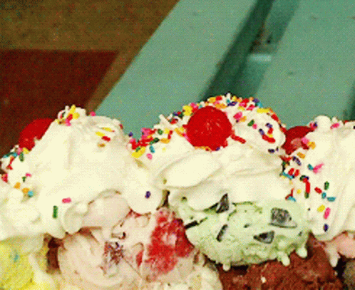 A Scoop Of Ice Cream With Whipped Cream And Sprinkles And A Cherry On Top GIF
