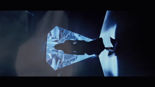 A Shadow Of A Person Is Cast On A Large Diamond In A Dark Room GIF