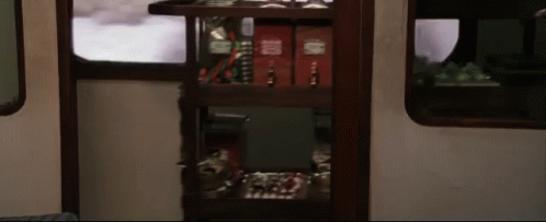 a shelf in a train car has a few books on it including one that says ' harry potter ' on it