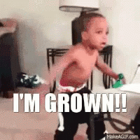 A Shirtless Baby Is Standing In A Room With The Words I 'M Grown ! GIF