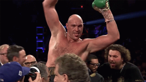 A Shirtless Boxer Is Being Congratulated By A Group Of People GIF