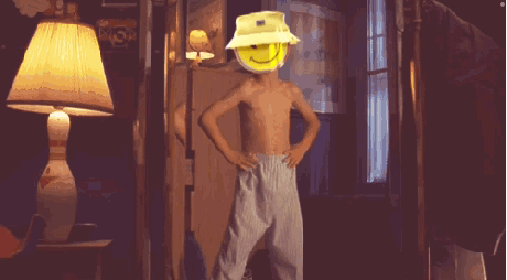 A Shirtless Boy Wearing A Yellow Hat With A Smiley Face On His Head GIF