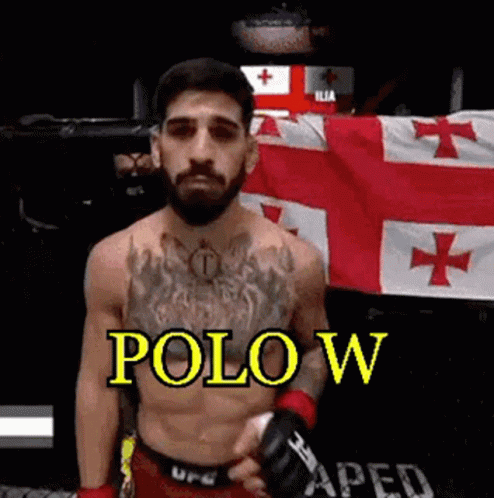 A Shirtless Fighter With A Beard Is Standing In Front Of A Flag And Holding A Glove . GIF