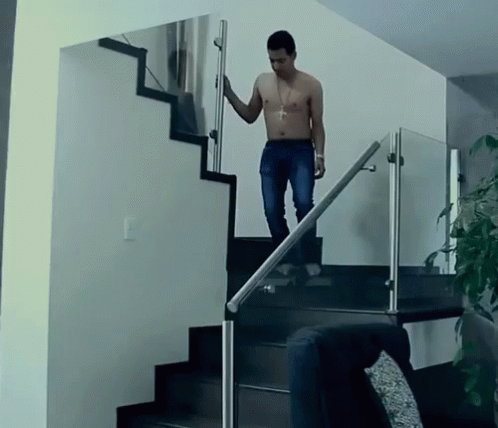 A Shirtless Man Climbs A Set Of Stairs With A Glass Railing GIF