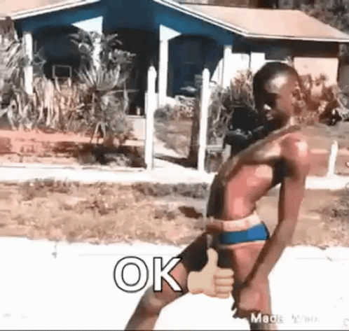 A Shirtless Man In A Bathing Suit Is Giving A Thumbs Up Sign . GIF