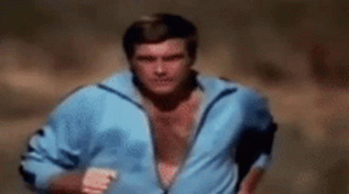 A Shirtless Man In A Blue Jacket Is Running . GIF