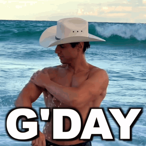 a shirtless man in a cowboy hat stands on the beach with the words g'day below him