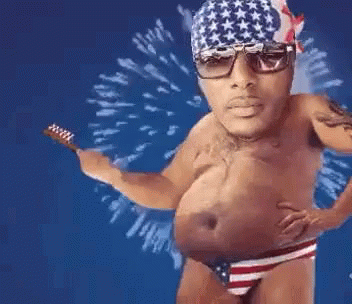 A Shirtless Man In An American Flag Underwear Is Holding A Toothbrush In His Hand . GIF