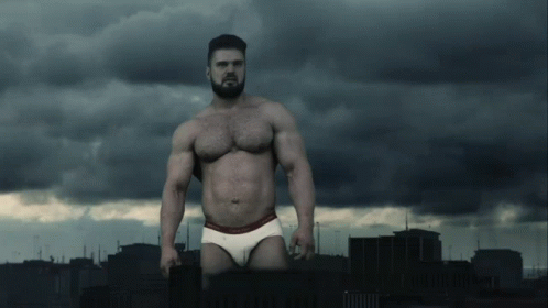 A Shirtless Man In Calvin Klein Underwear Stands In Front Of A City GIF