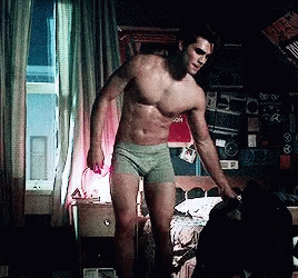 A Shirtless Man In Green Underwear Is Standing In Front Of A Bed GIF