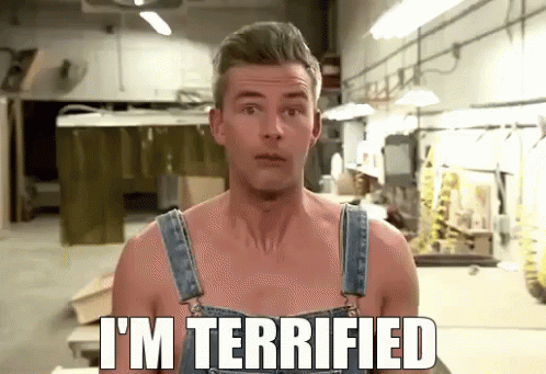A Shirtless Man In Overalls Says I 'M Terrified In A Workshop GIF