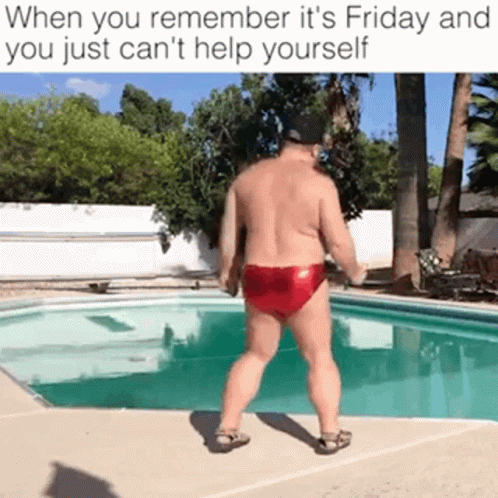 A Shirtless Man In Red Swim Trunks Is Standing In Front Of A Pool . GIF
