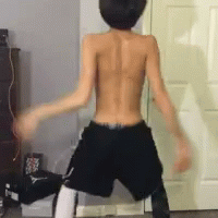 A Shirtless Man In Shorts Is Dancing In Front Of A Door GIF