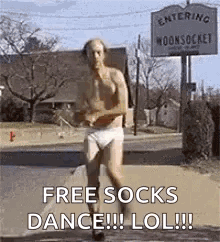 A Shirtless Man In Underwear Is Running Down A Street In Front Of A Sign That Says Free Socks Dance Lol . GIF