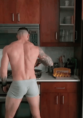 A Shirtless Man In Underwear Is Standing In A Kitchen Cooking GIF