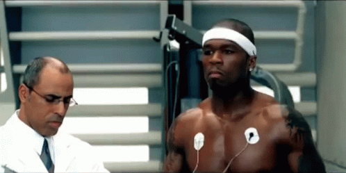 A Shirtless Man Is Being Examined By A Doctor While Wearing A Headband . GIF
