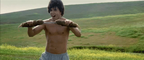 A Shirtless Man Is Carrying A Large Piece Of Wood On His Shoulders . GIF