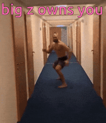 A Shirtless Man Is Dancing In A Hallway With The Words " Big Z Owns You " Above Him GIF