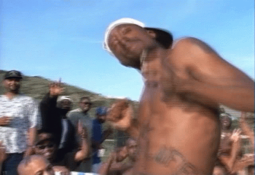 A Shirtless Man Is Dancing In Front Of A Crowd Of People GIF
