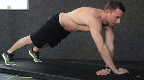 A Shirtless Man Is Doing A Plank On A Mat GIF
