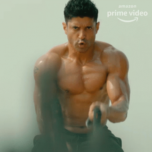 A Shirtless Man Is Doing Exercises In Front Of An Amazon Prime Video Advertisement GIF