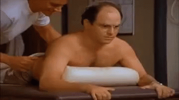 A Shirtless Man Is Getting A Massage From A Nurse While Laying On A Table . GIF
