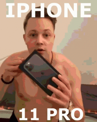 A Shirtless Man Is Holding A Black Iphone 11 Pro GIF