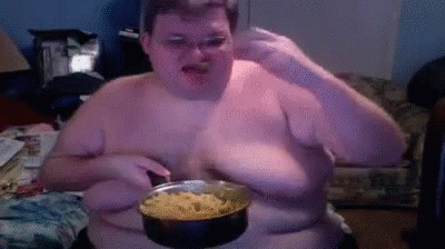 A Shirtless Man Is Holding A Pot Of Food In Front Of His Face GIF