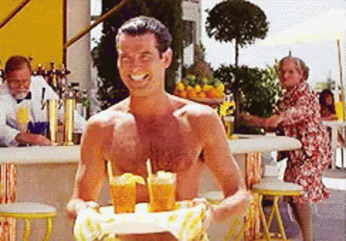A Shirtless Man Is Holding A Tray Of Drinks GIF