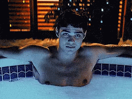 A Shirtless Man Is Laying In A Bubble Bath GIF